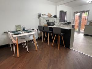 a kitchen with a table and chairs and a counter at Slick Space for a Standish Stay in Standish