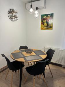 een eettafel met stoelen en een schilderij aan de muur bij Vila Galerija in Vukovar