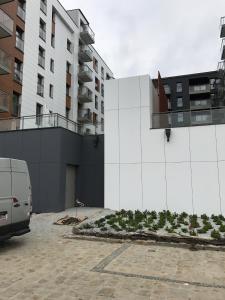 uma carrinha estacionada num parque de estacionamento ao lado de um edifício em Apartament Lux Gdańsk Nowa Motława em Gdańsk