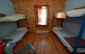 a room with two bunk beds and a window at Auberge jeunesse de Tadoussac in Tadoussac