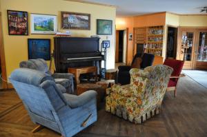 a living room with two chairs and a piano at Auberge jeunesse de Tadoussac in Tadoussac