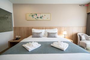 a hotel room with a bed with towels on it at Chinatown Living Hatyai in Hat Yai