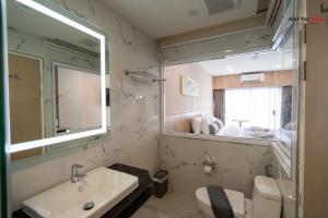 a bathroom with a sink and a toilet and a mirror at Chinatown Living Hatyai in Hat Yai