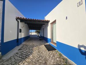 un couloir d'un bâtiment avec un mur bleu et blanc dans l'établissement Sunflower Castle View in Óbidos, à Óbidos