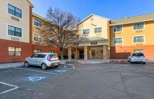 twee auto's geparkeerd op een parkeerplaats voor een gebouw bij Extended Stay America Suites - Salt Lake City - West Valley Center in West Valley City