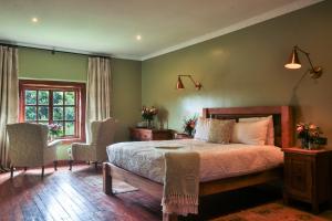 een slaapkamer met een bed en 2 stoelen en een raam bij Mukima Manor in Nanyuki