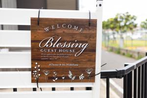 船橋市にあるBlessing Guest Houseの白いベンチのゲストハウスの看板