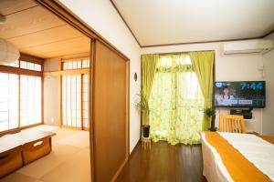 船橋市にあるBlessing Guest Houseのベッドルーム(ベッド1台、テレビ、窓付)