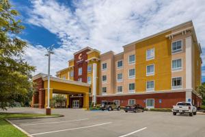 um hotel com carros estacionados num parque de estacionamento em Comfort Suites Denham Springs em Denham Springs