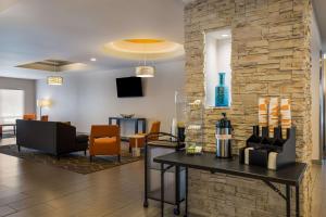 um átrio com uma mesa com garrafas de vinho em Comfort Suites Denham Springs em Denham Springs