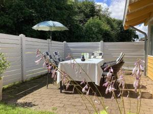 a table and chairs with an umbrella in a backyard at Holiday home Aabenraa LXXIX in Aabenraa