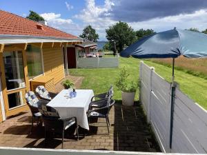 a table and chairs with an umbrella on a patio at Holiday home Aabenraa LXXIX in Aabenraa