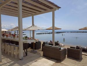 une terrasse avec bar, chaises et eau dans l'établissement Corfu Holiday Palace, à Corfou