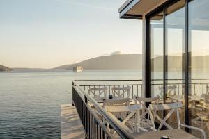 una terraza con sillas y vistas al agua en SkyView apartments, en Herceg-Novi