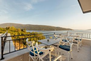 balcón con mesas y sillas y vistas al agua en SkyView apartments, en Herceg-Novi