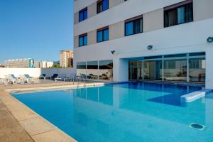 uma piscina em frente a um edifício em VIP Executive Zurique Hotel em Lisboa