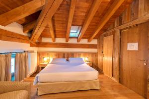 ein Schlafzimmer mit einem Bett in einem Zimmer mit Holzwänden in der Unterkunft Le Miramonti Hotel Restaurant & Wellness in La Thuile