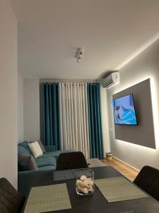 uma sala de estar com um sofá e uma televisão em Jur Apartment em Durrës