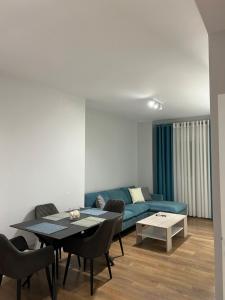 uma sala de estar com um sofá azul e uma mesa em Jur Apartment em Durrës