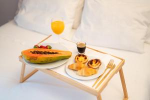 ein Tablett mit einem Obstteller und einem Glas Orangensaft in der Unterkunft Seaside Cozy Apartment with private Terrace in Porto