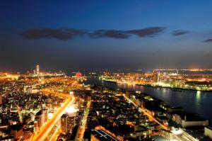 une ville éclairée la nuit avec une rivière dans l'établissement Art Hotel Osaka Bay Tower, à Osaka