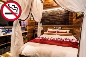 - une chambre avec un lit et un panneau non-fumeurs dans l'établissement Petit Bali Forest Shinjuku Sanchōme, à Tokyo