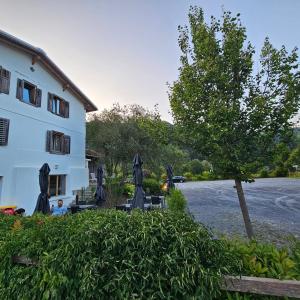 un bâtiment avec un arbre à côté d'un bâtiment dans l'établissement Landgasthof zum Glenner, à Ilanz