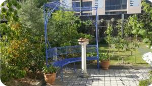 un banc bleu avec une couronne dans un jardin dans l'établissement Studio, entrée par terrasse, à Genève