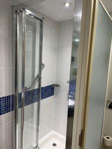 ein Bad mit einer Dusche und blauen Fliesen in der Unterkunft Holiday Inn Express London - Epsom Downs, an IHG Hotel in Epsom