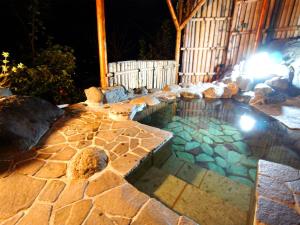 伊东We Home Villa - Jogasaki Onsen - - Vacation STAY 13634v的一座晚上在院子里的游泳池里放岩石