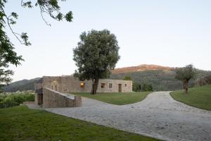 un edificio de piedra con un camino de tierra delante de él en Quinta do Outeiro 1598, en Ponte da Barca