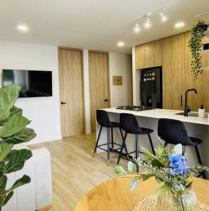 a kitchen with black chairs and a kitchen island at Apartamento Entero en Pinares Pereira in Pereira