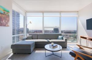 ein Wohnzimmer mit einem Sofa und einem großen Fenster in der Unterkunft Level Los Angeles - Downtown South Olive in Los Angeles