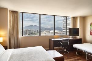 una camera d'albergo con letto, scrivania e finestra di Residence Inn by Marriott Rio de Janeiro Barra da Tijuca a Rio de Janeiro