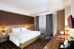 เตียงในห้องที่ Swiss-Belinn Tunjungan Surabaya