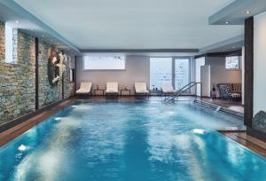 ツェルマットにあるSCHLOSS Zermatt - Active & CBD Spa Hotelのホテルの部屋のプール(椅子付)