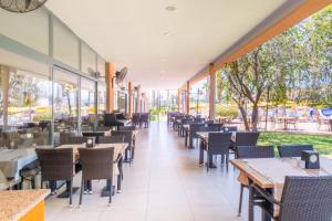 un restaurant avec des tables, des chaises et des fenêtres dans l'établissement Viking Park Hotel, à Kemer