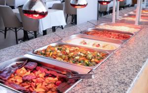 un buffet avec plusieurs plateaux de nourriture sur un comptoir dans l'établissement Viking Park Hotel, à Kemer