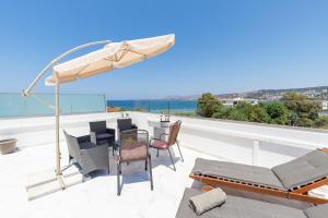 a balcony with a table and chairs and an umbrella at Notus Chania Crete in Chania Town