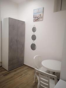 een witte eetkamer met een tafel en een kast bij Terracina Holiday Succursale in Terracina