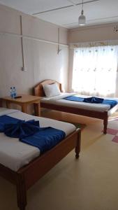 two beds sitting in a room with a window at Taphe Resort Naivasha in Naivasha