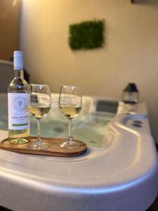 a bottle of wine and two wine glasses on a counter at Várfal apartman II in Eger