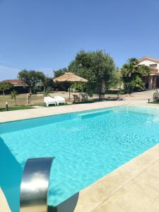 une grande piscine d'eau bleue dans l'établissement Villa Marianna, à Alghero