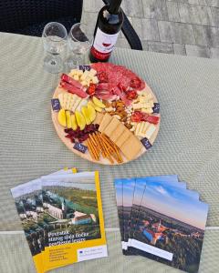 uma mesa com um prato de comida e uma garrafa de vinho em Studio apartman Dora em Ilok