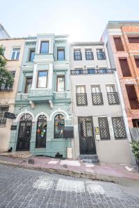 a blue and white building with black doors on a street at Calanthe Residence in Istanbul