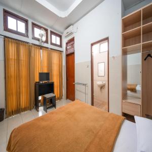 Hotel Dewata Indah Denpasar Mitra RedDoorz में एक कमरे में एक या कई बेड