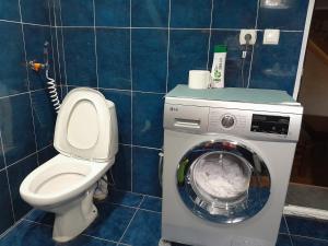 a bathroom with a toilet and a washing machine at Guest House Metreveli in Borjomi