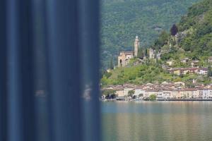 una ciudad en una colina junto a un cuerpo de agua en Villa Patria B&B, en Brusino Arsizio