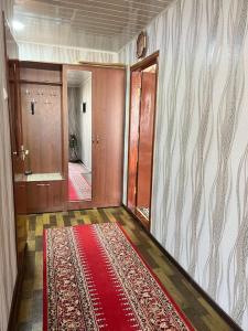 um corredor vazio com um tapete vermelho no chão em Firdausi Apartment em Khujand