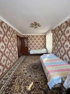 um quarto com 2 camas num quarto com papel de parede em Firdausi Apartment em Khujand